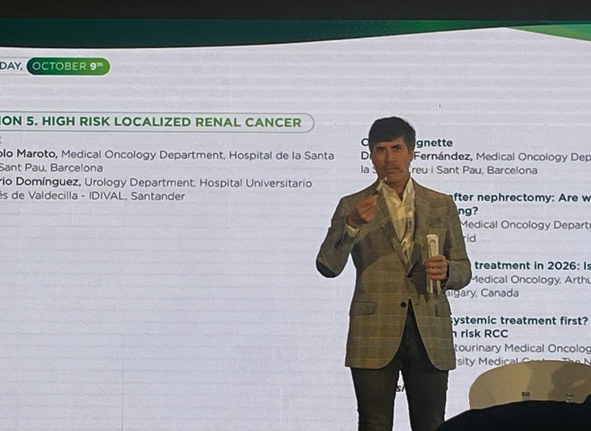 Mario Domínguez Esteban hablando delante de la diapositiva de la sesión 5, cáncer renal localizado de alto riesgo, en los GO Norte GU Debates de Limpias