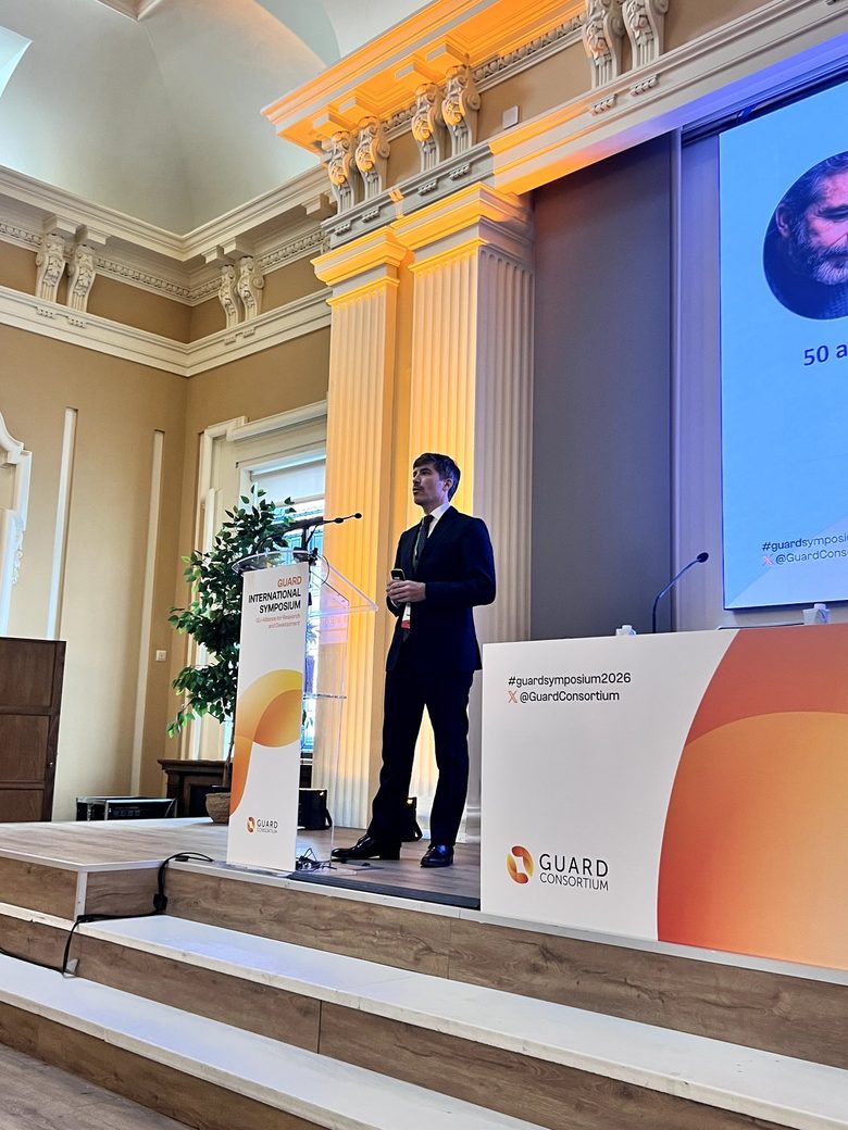 Mario Domínguez Esteban, de pie en el escenario del GUARD International Symposium 2026 en Madrid, durante su charla sobre la aplicación de la IA en el diagnóstico precoz del cáncer de próstata